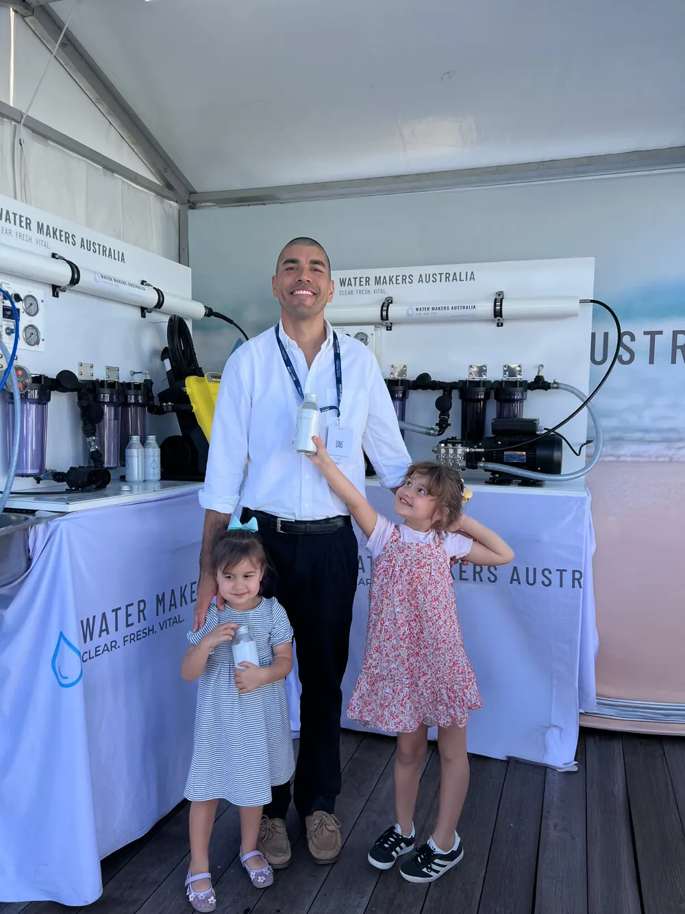 Water Makers Australia founder Kalim Scharenguivel with his two daughters at the company’s boat-show display